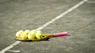 a tennis racket and four tennis balls on a tennis court