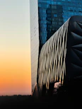 Modern architectural facade with clean lines and glass elements at sunset.