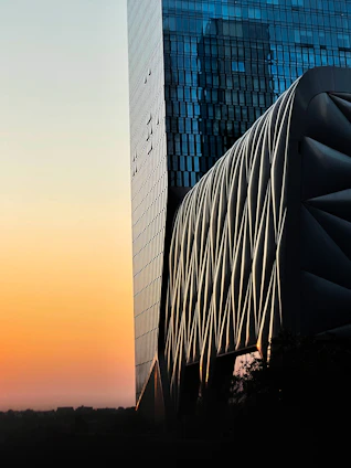A sleek architectural structure bathed in sunset orange light, symbolizing innovation and travel connections.