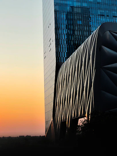 A sleek modern architectural building with clean lines and glass facade at sunset.