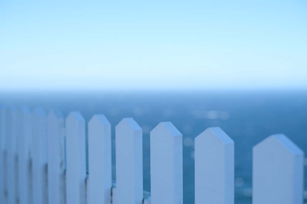 a blurry photo of a white picket fence