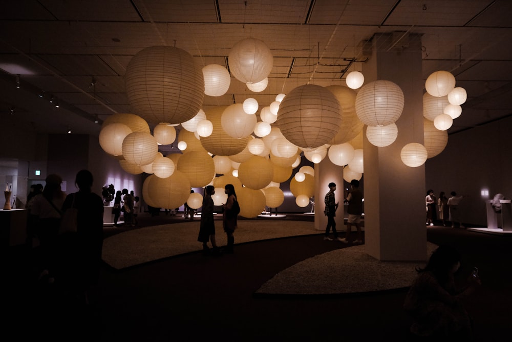 a room filled with lots of white paper lanterns