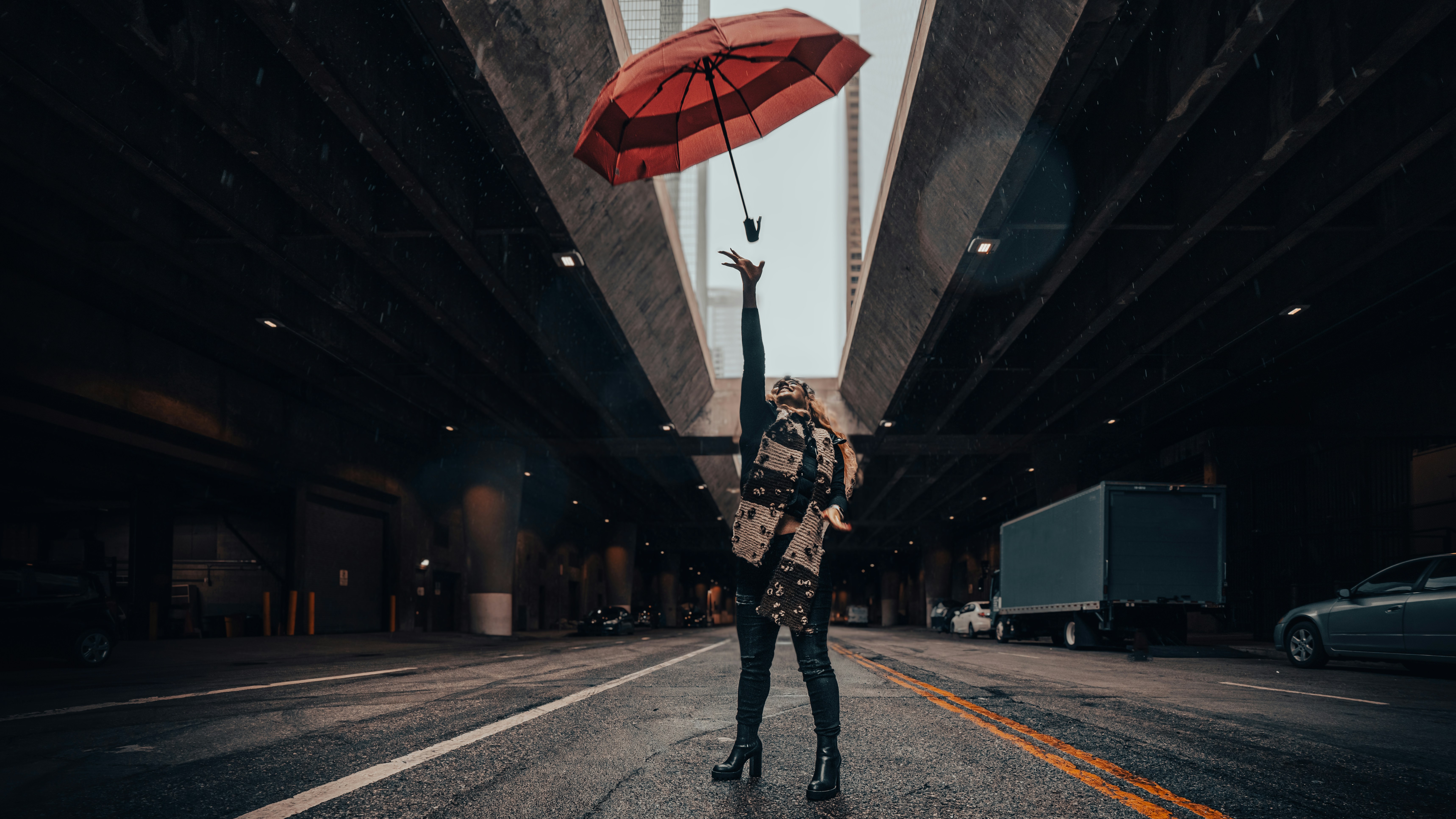 a woman holding an umbrella in the middle of a street