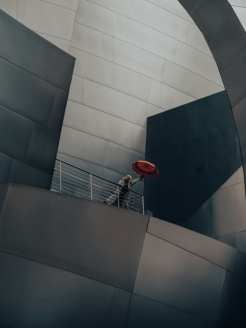 a man holding a red frisbee on top of a metal structure