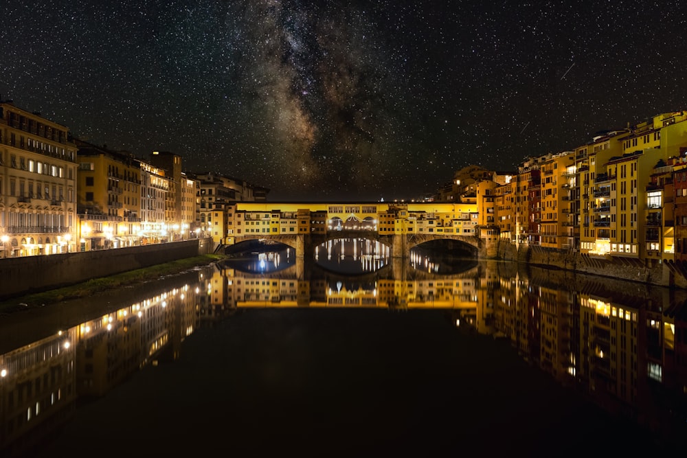 a night view of a river with buildings and a bridge