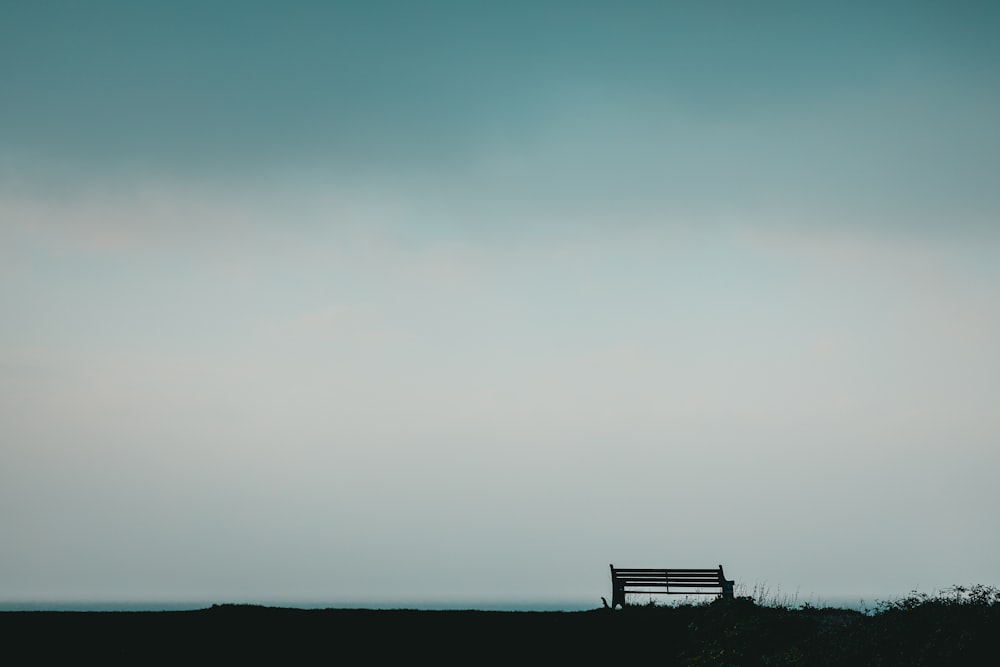 un banc assis au-dessus d’un champ couvert d’herbe