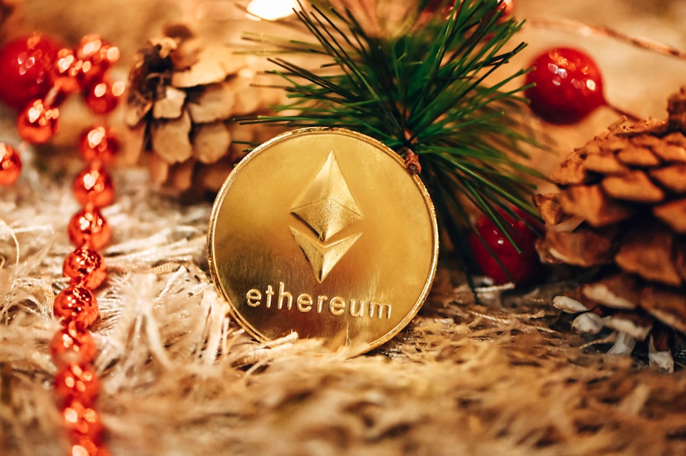 a gold ethereum coin sitting on top of a pile of pine cones