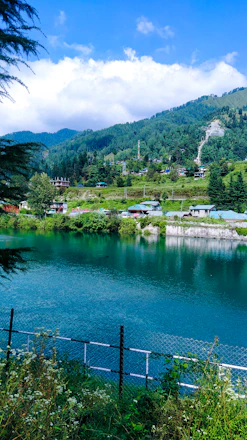 a body of water surrounded by a lush green hillside