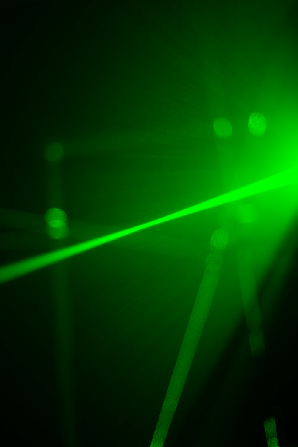 a green laser is shining in the dark