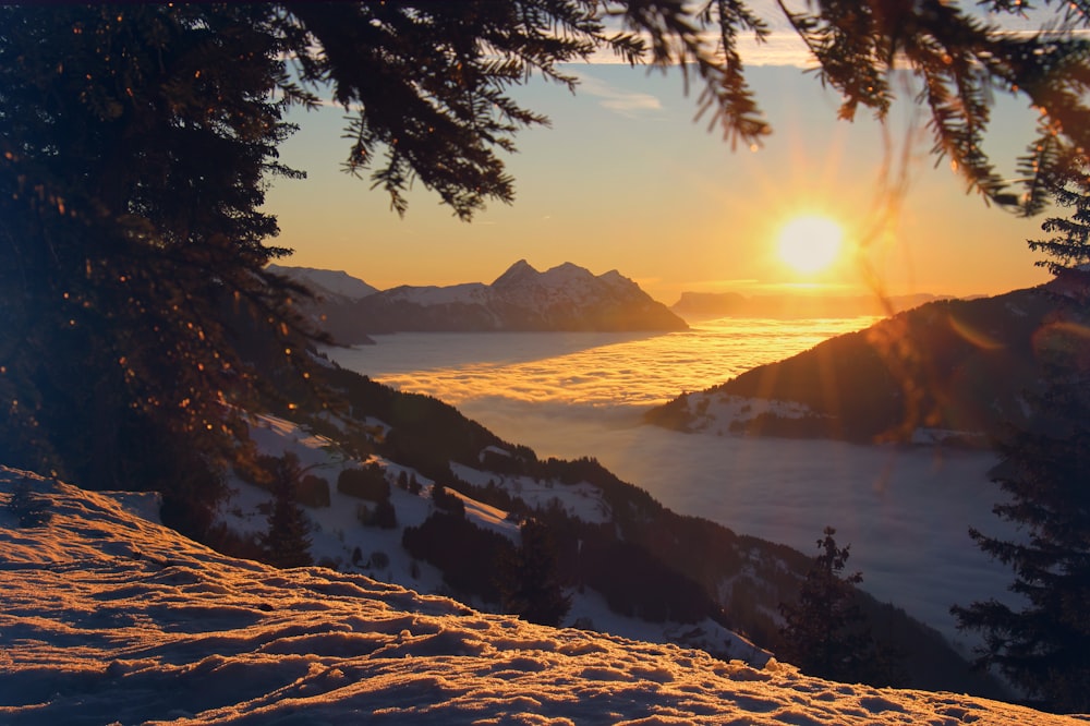 Le soleil se couche sur une chaîne de montagnes enneigée
