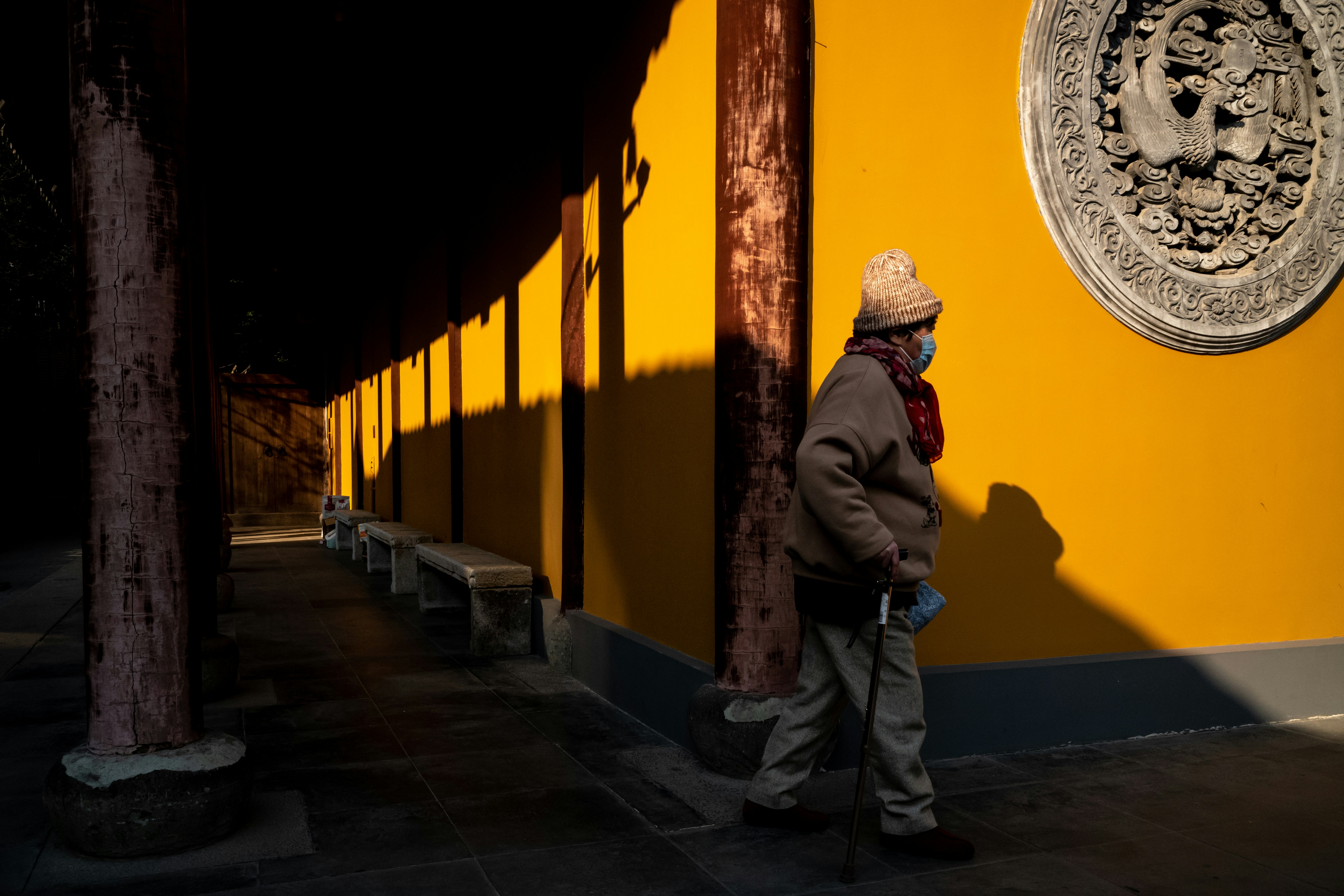 a man standing in front of a yellow wall