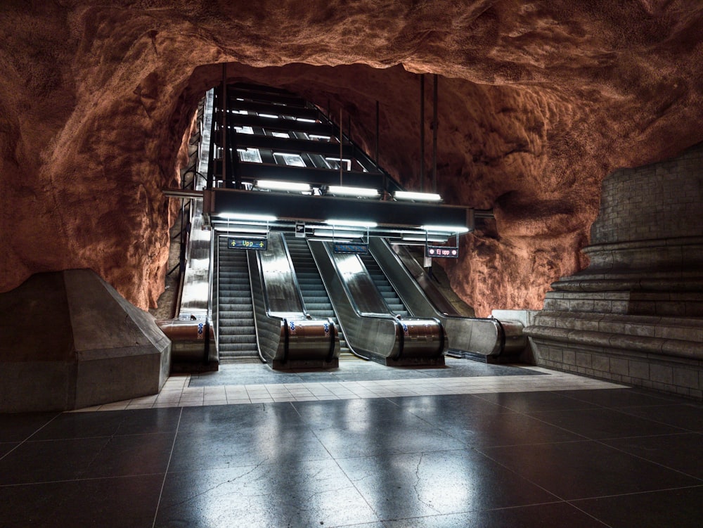 an escalator in a cave with stairs leading up to it