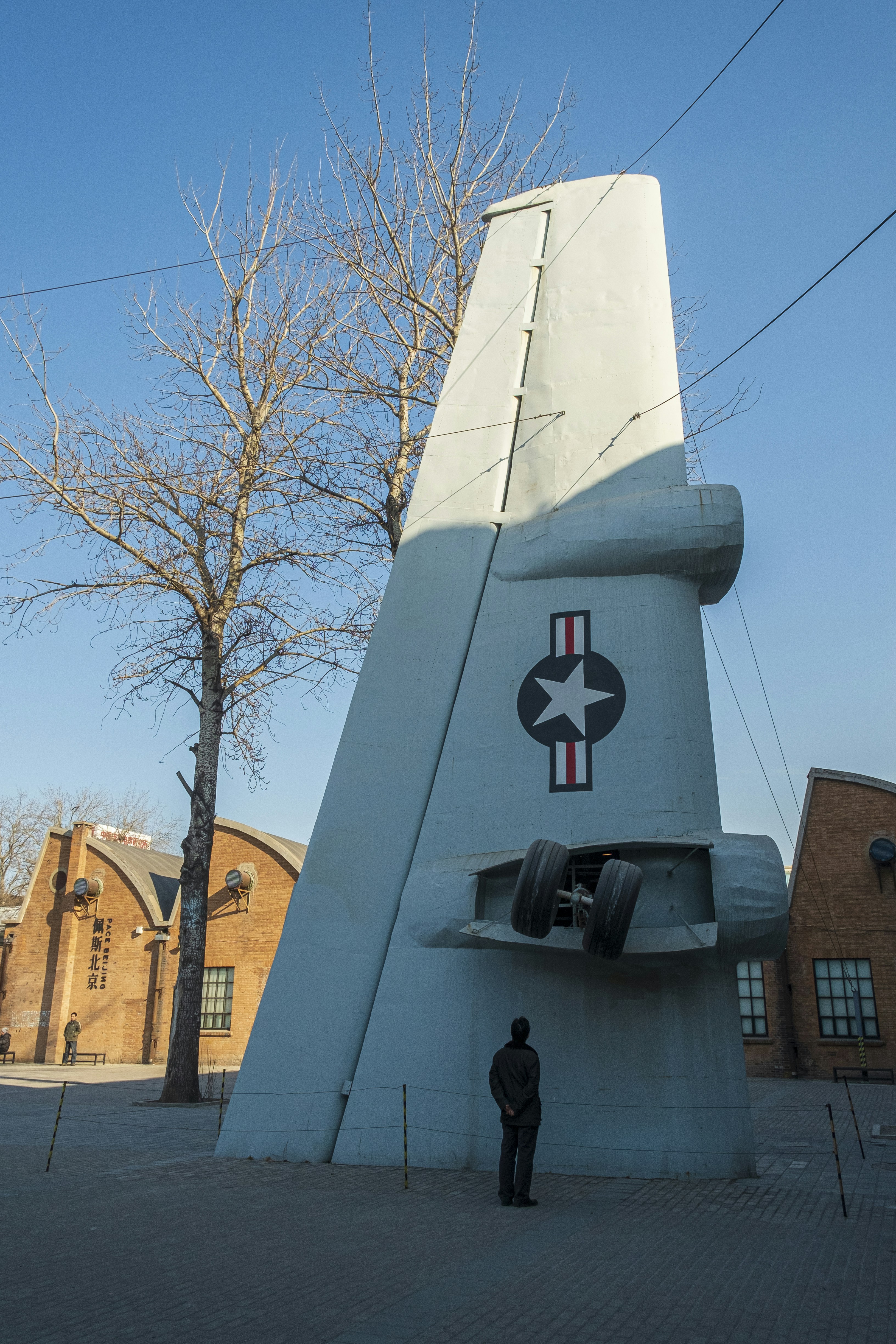 Un hombre parado frente a una gran escultura