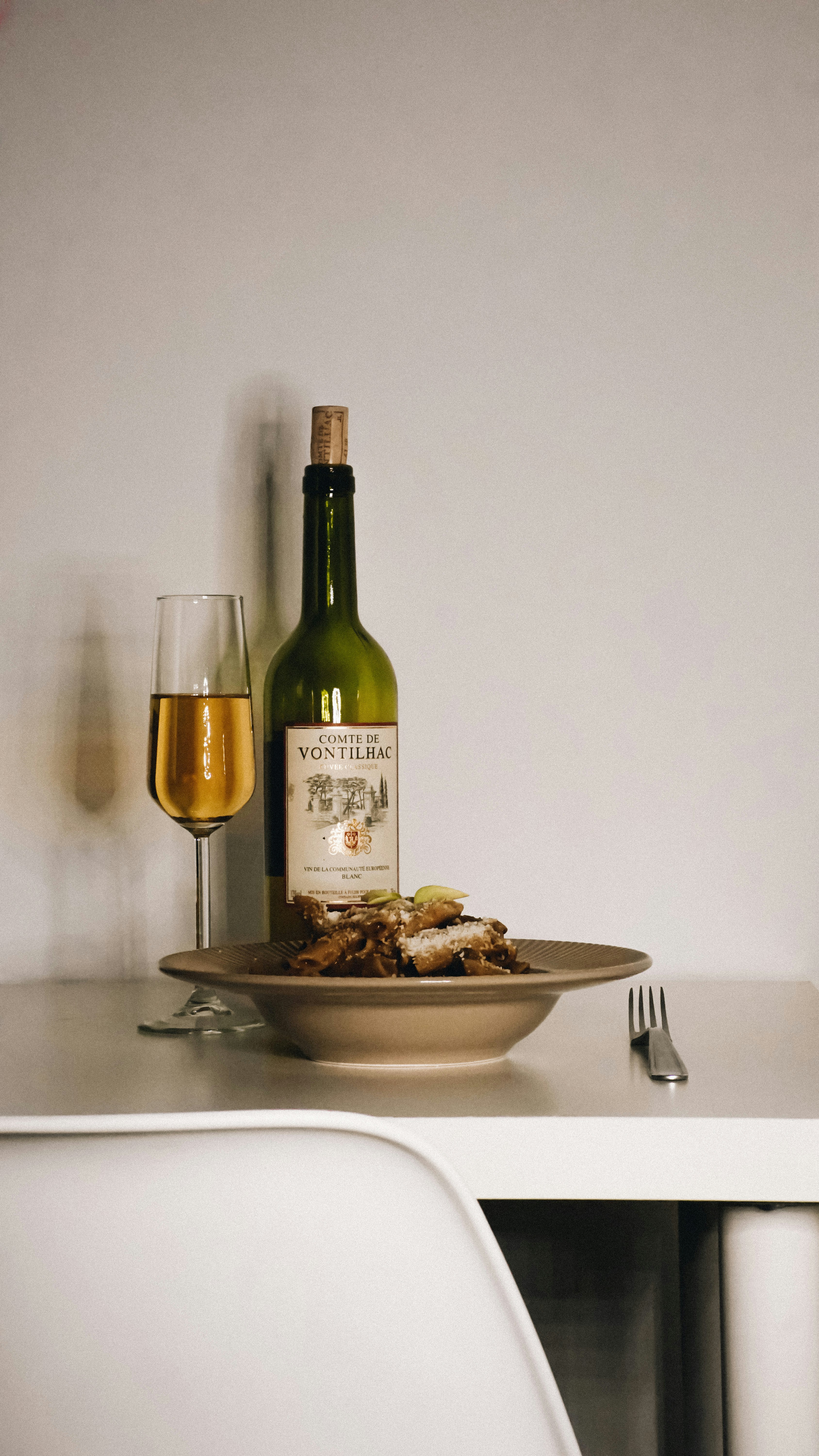 a plate of food and a bottle of wine on a table