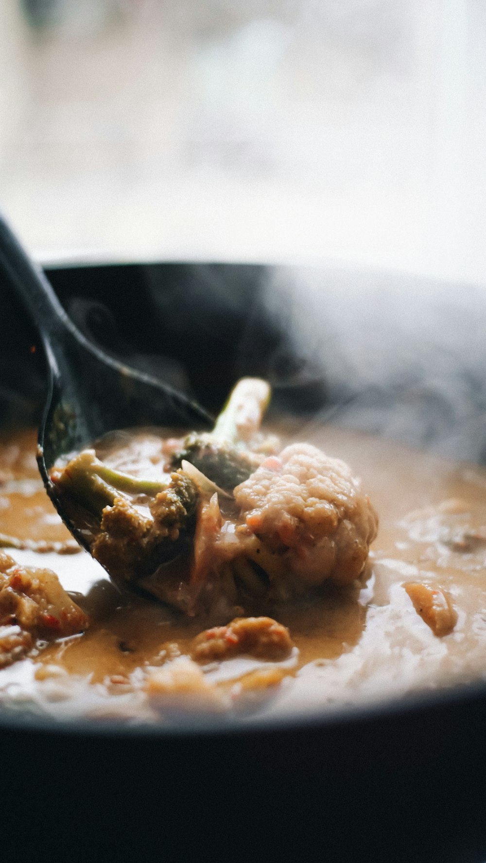 a close up of a spoon in a bowl of soup