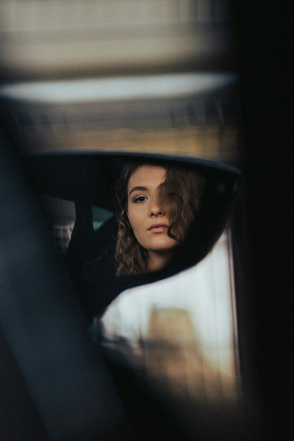 a woman sitting in a car looking out the window