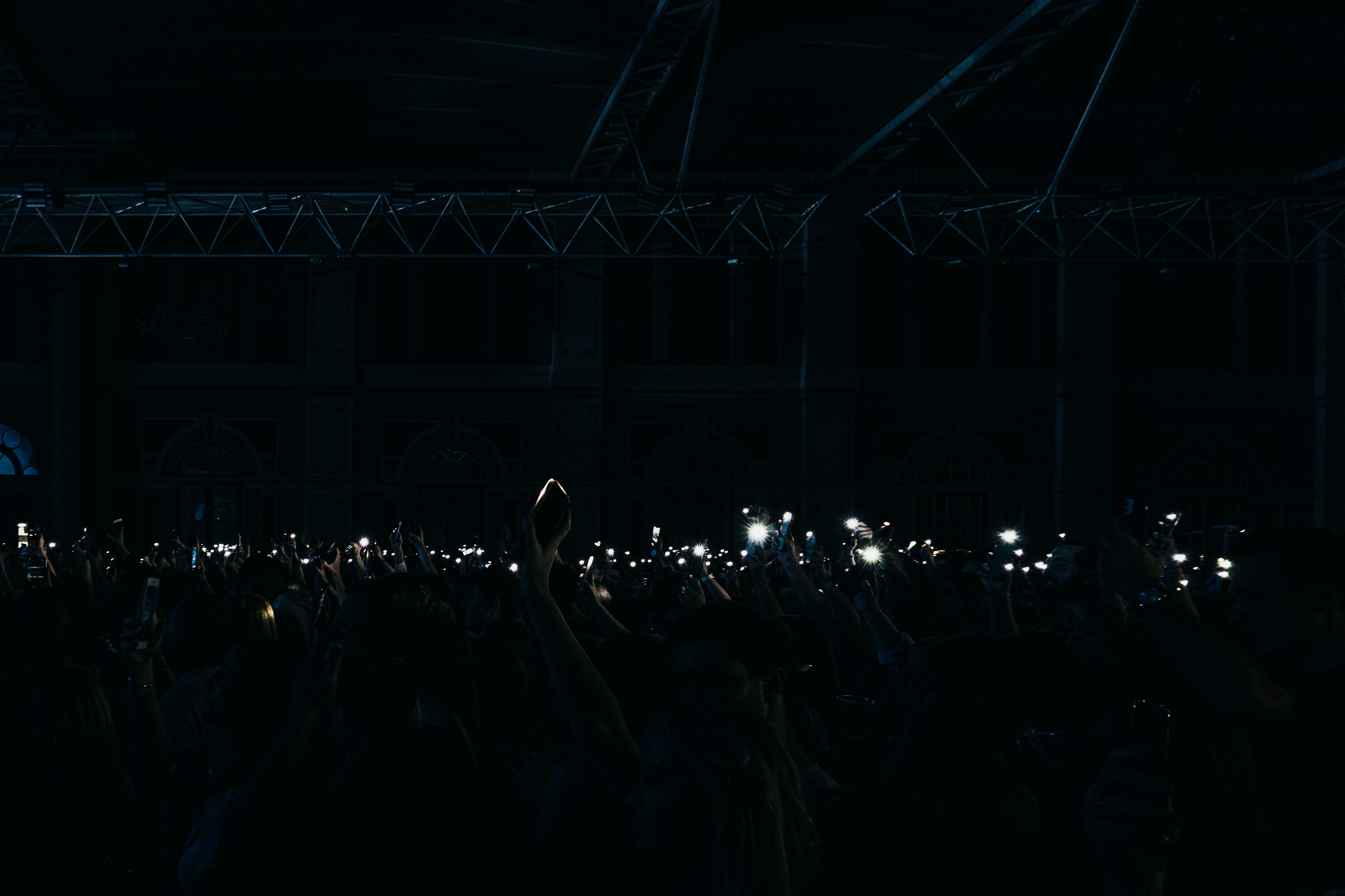a crowd of people holding up their cell phones