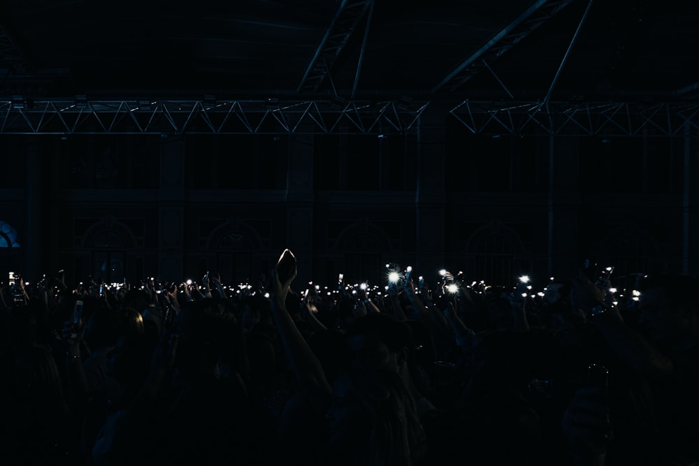 a crowd of people holding up their cell phones