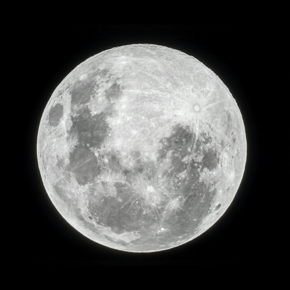 a full moon is shown in the dark sky