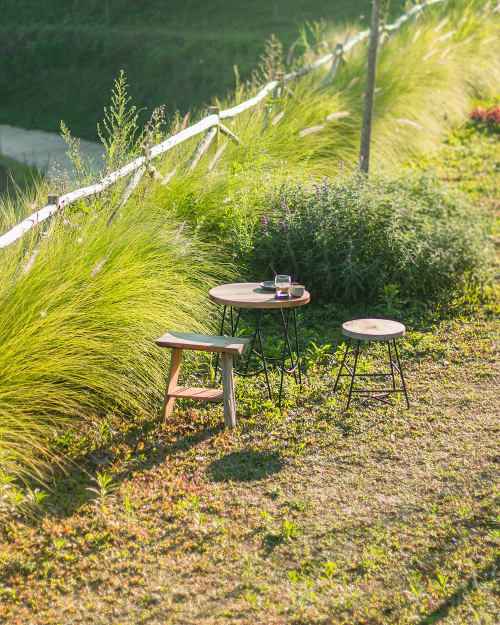 a couple of wooden tables sitting on top of a grass covered field