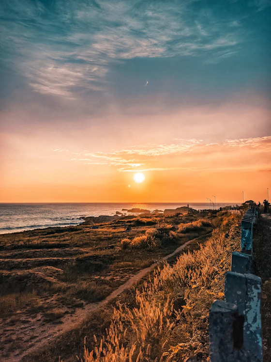 The sun setting over the ocean from the shore at Kanyakumari