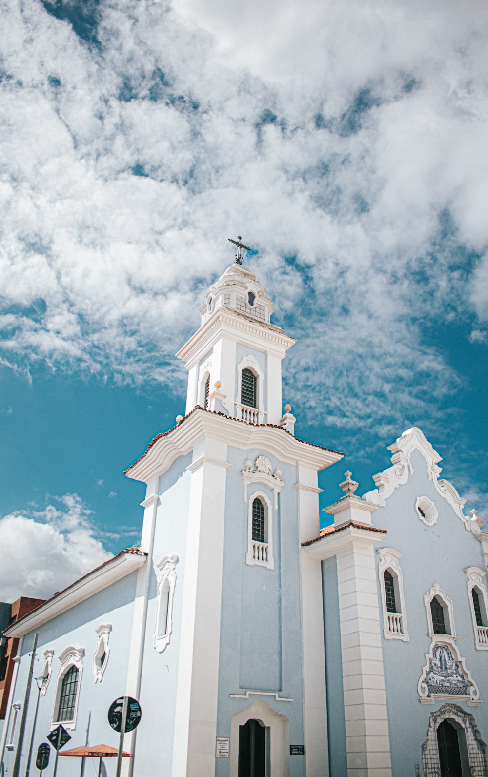 a white and blue church with a cross on top