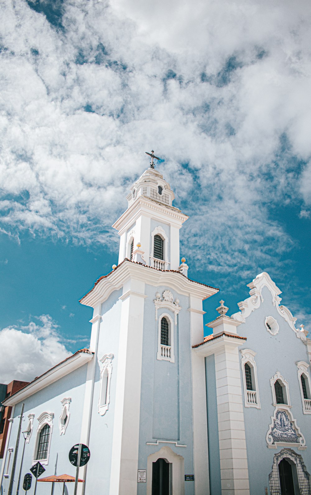 uma igreja branca e azul com uma cruz no topo