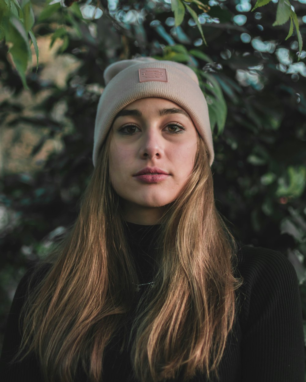 a woman with long hair wearing a beanie