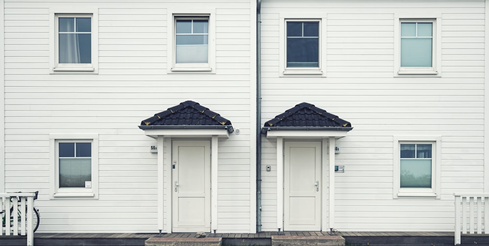 a couple of white doors sitting next to a white building