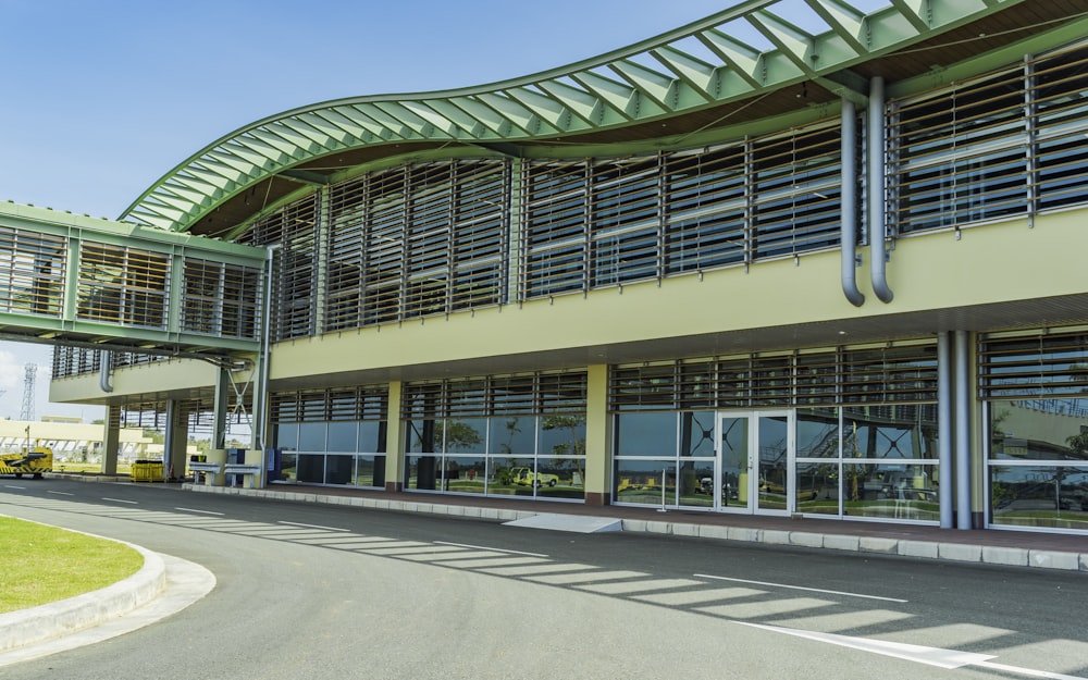 a large building with a green roof and a curved walkway