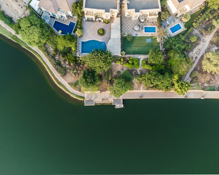 Aerial view of a detached villa with a private swimming pool and garden