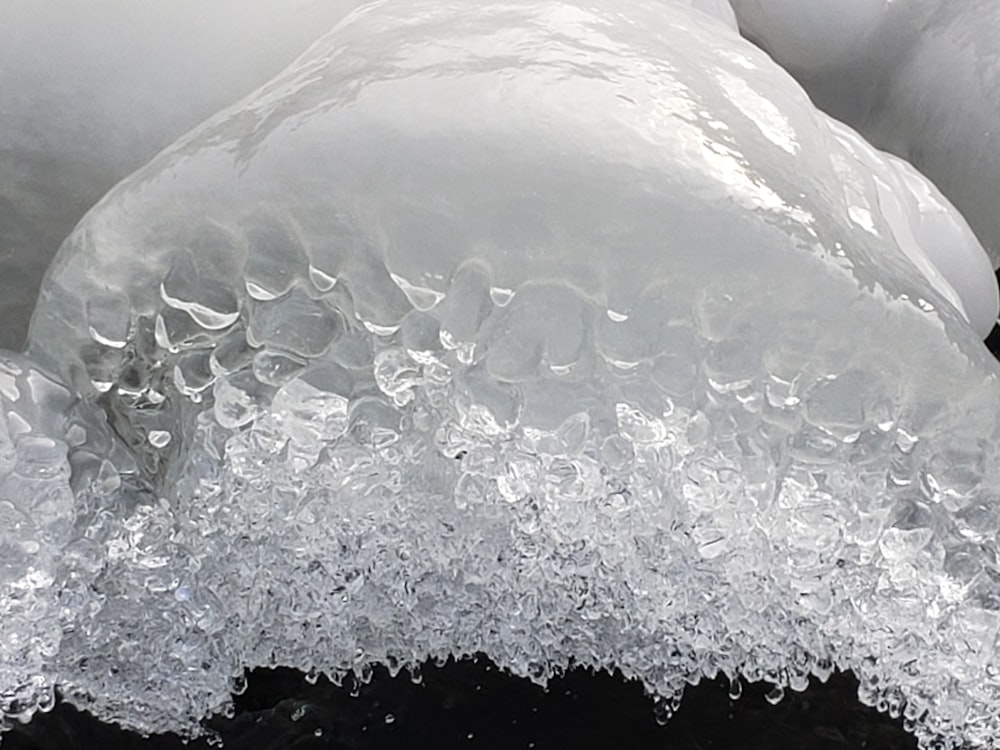 a close up of ice and water on a black surface