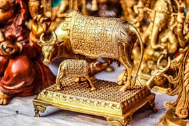 a gold cow statue sitting on top of a wooden platform