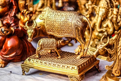 a gold cow statue sitting on top of a wooden platform