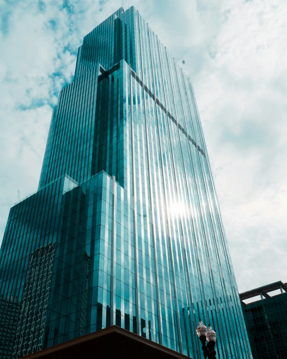 a tall glass building with a sky background