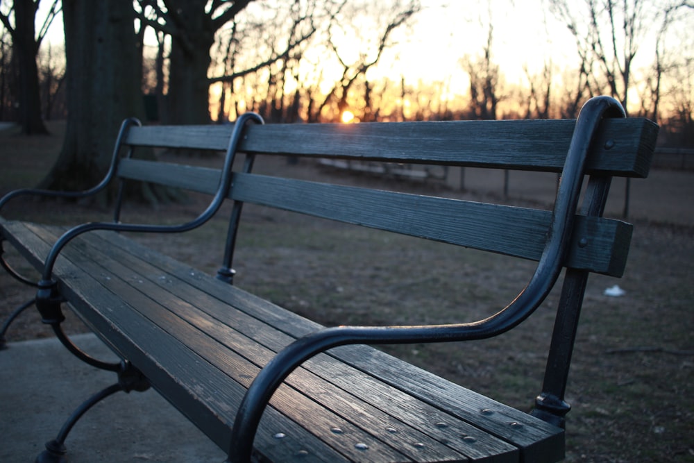 a park bench with the sun setting in the background