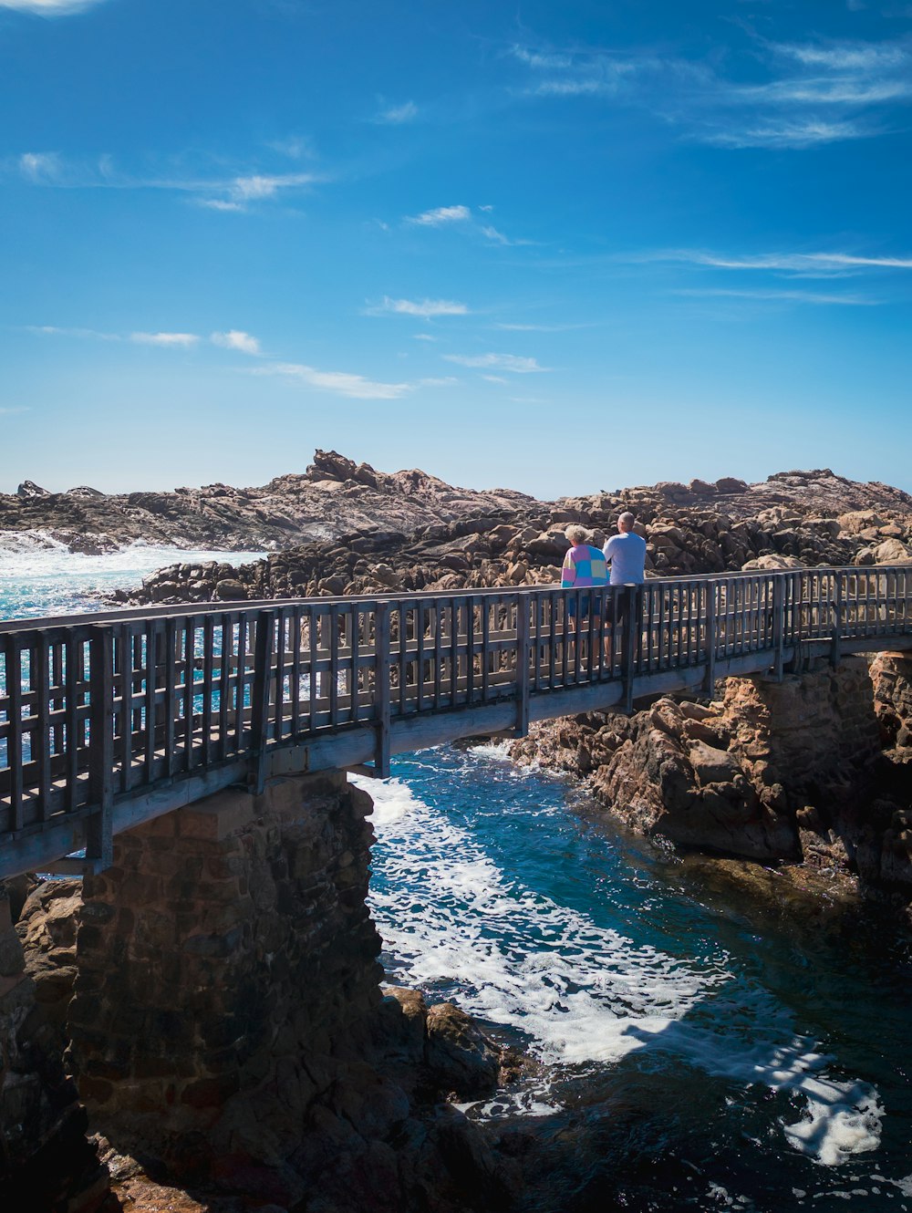 a couple of people that are standing on a bridge