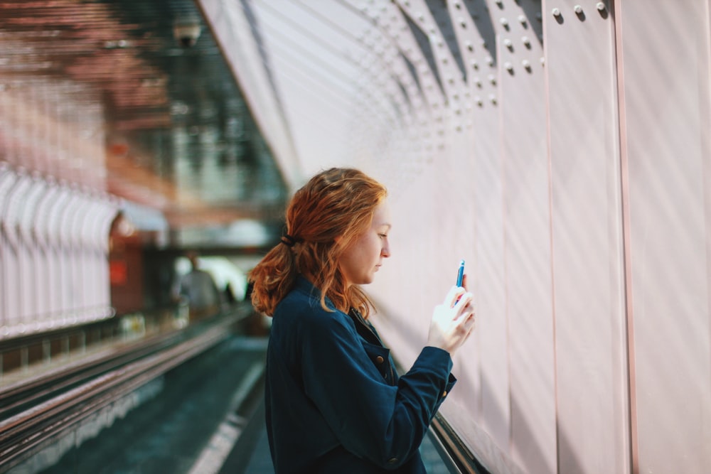 a woman writing on a wall next to a train