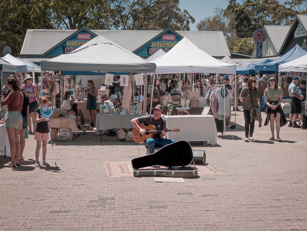 Un uomo che suona una chitarra di fronte a una folla di persone