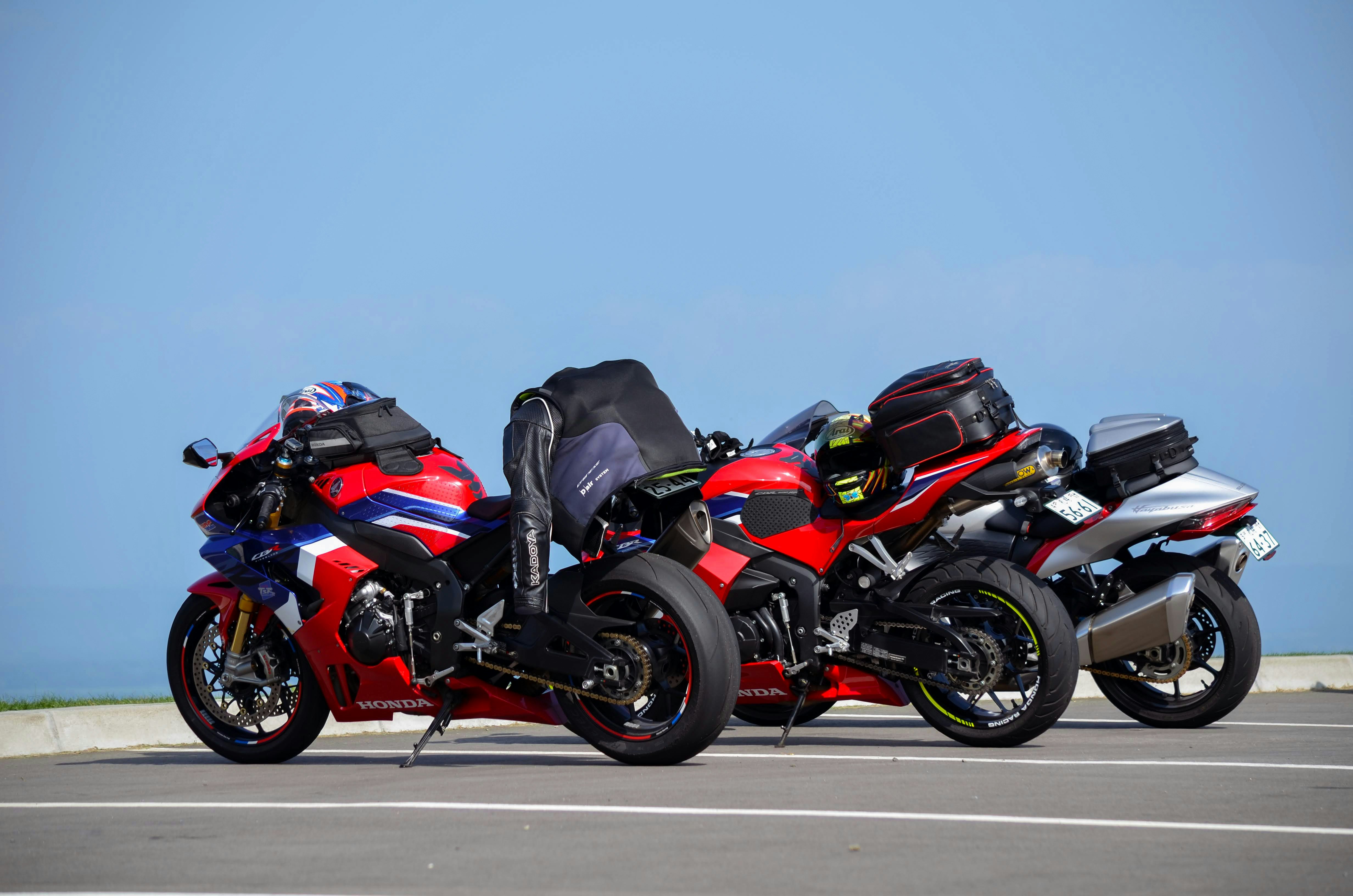 three motorcycles parked next to each other in a parking lot