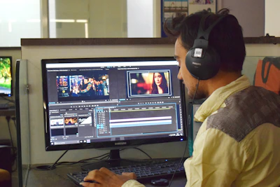 a man sitting in front of a computer with headphones on