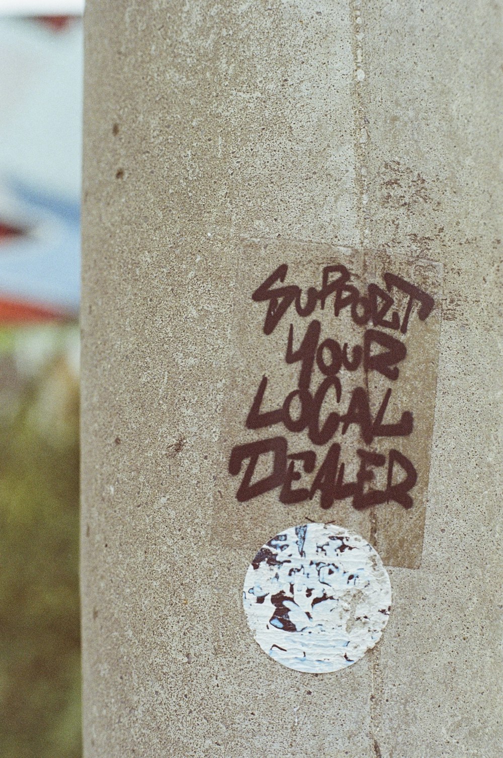 a sticker on the side of a cement pillar
