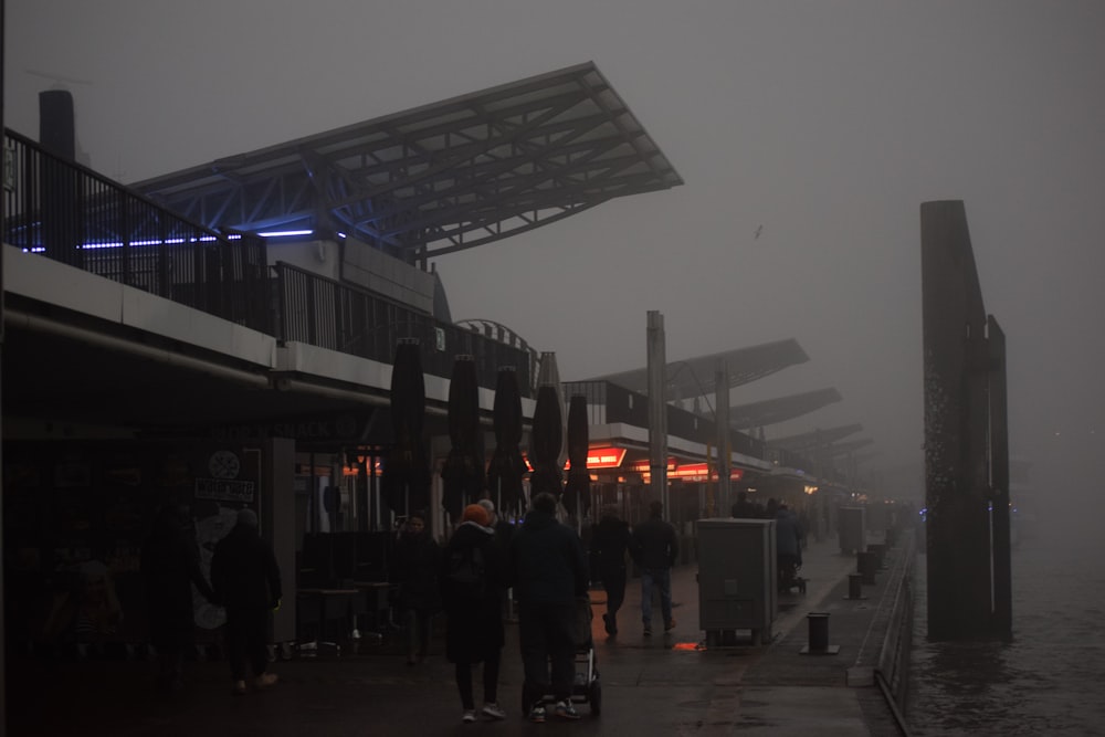 a group of people standing on a pier in the fog