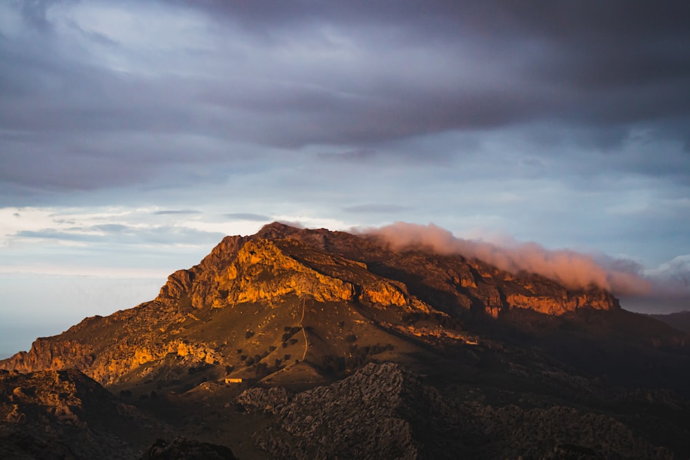 a very tall mountain with some clouds in the sky