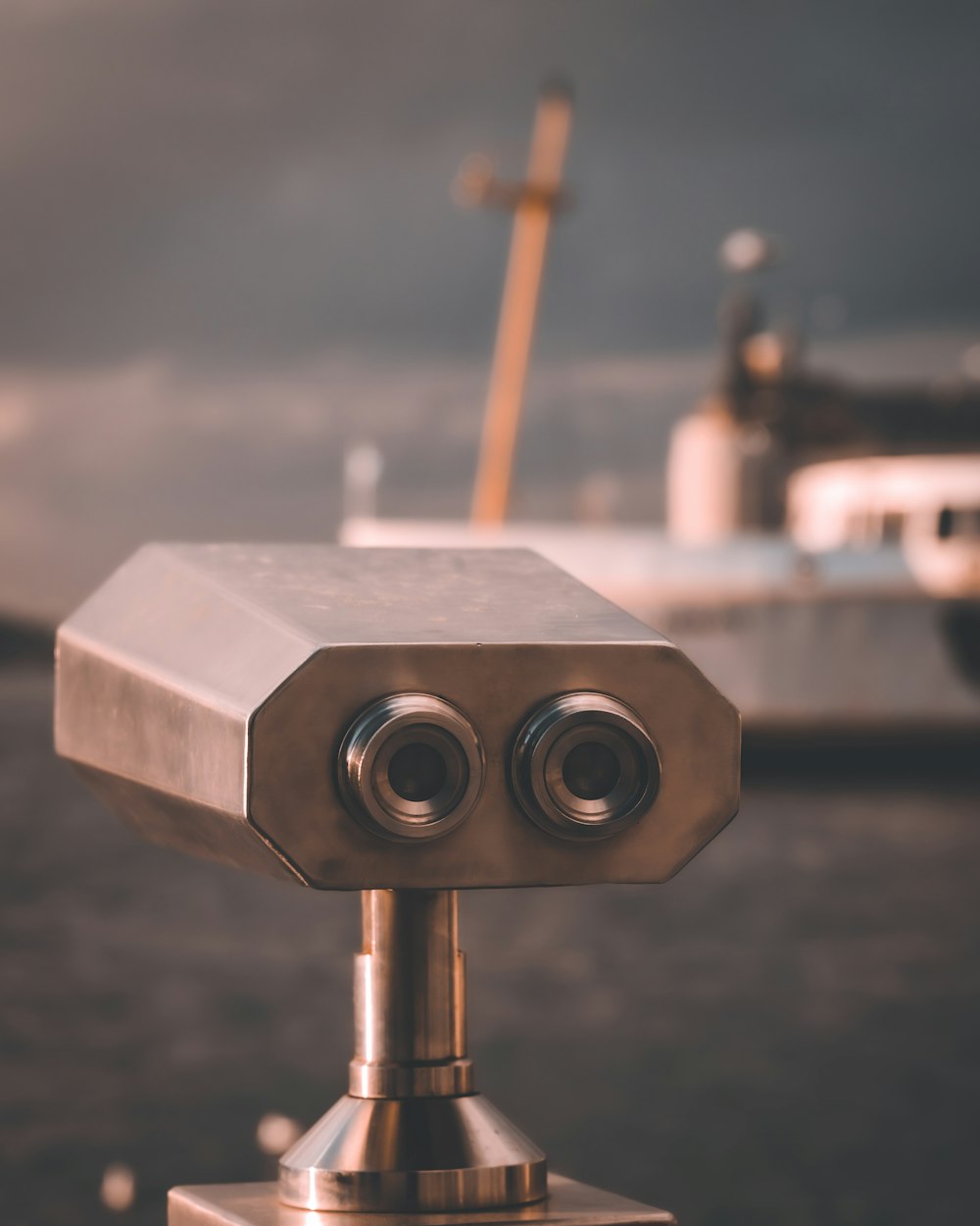 a close up of a metal object with a boat in the background