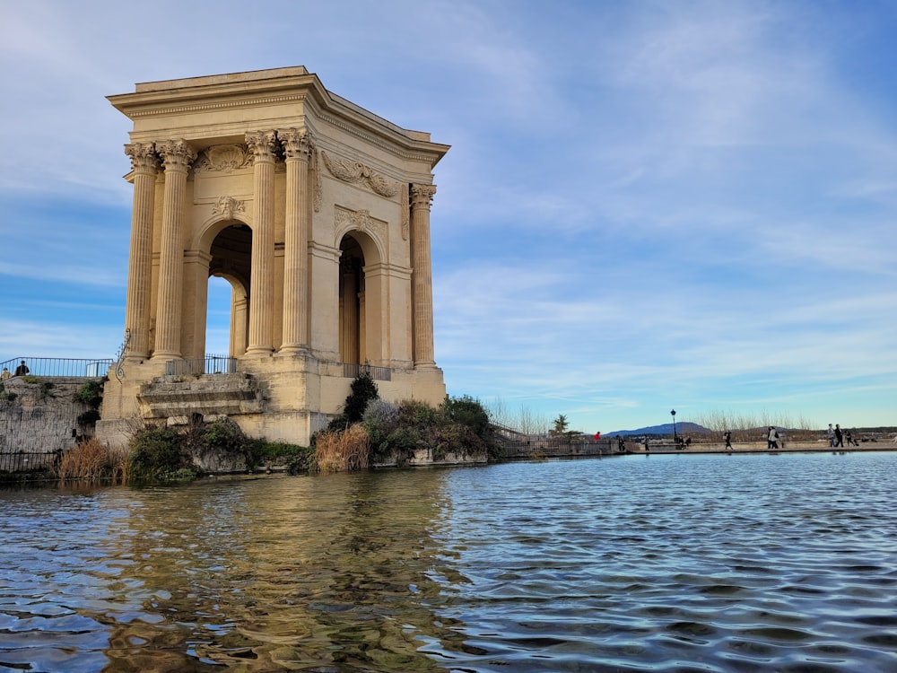 un grand bâtiment assis au-dessus d’un plan d’eau