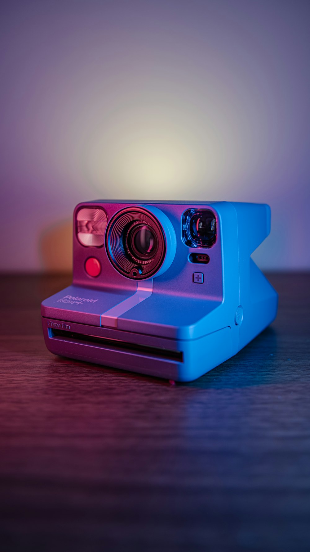 Eine Polaroidkamera sitzt auf einem Holztisch