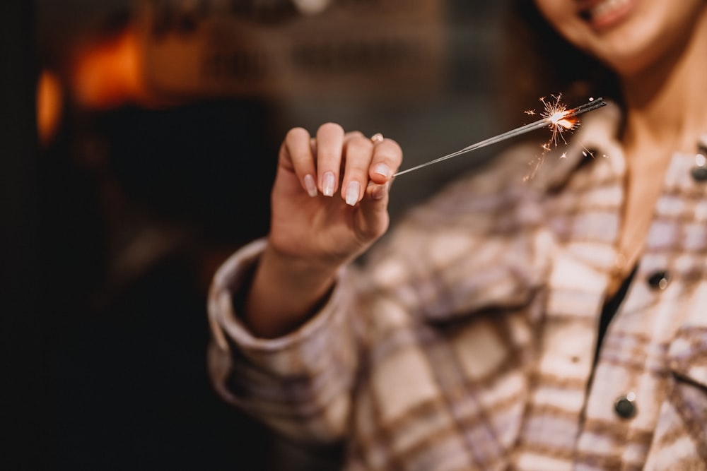 a woman holding a sparkler in her hand