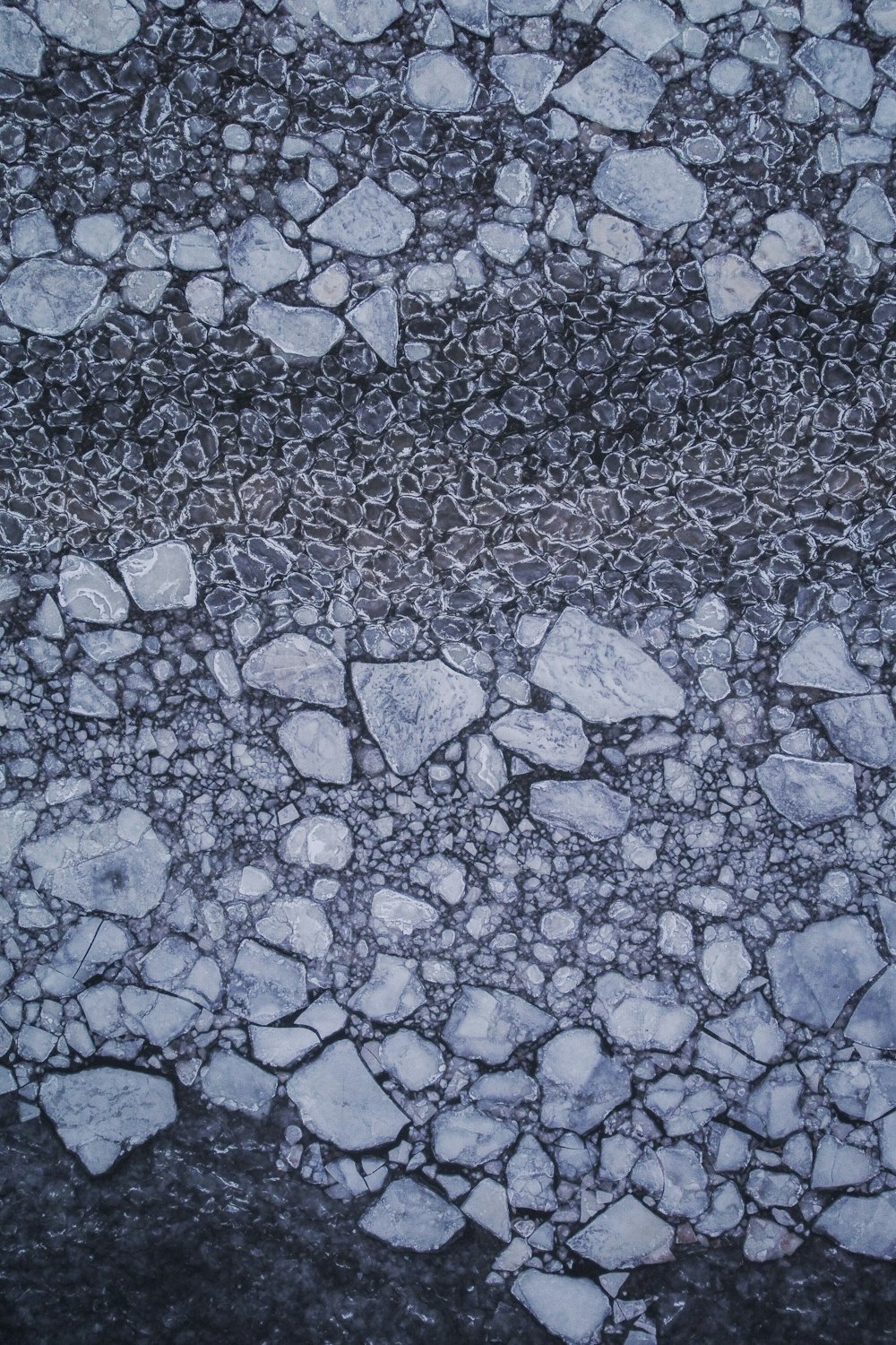 a black and white photo of rocks and water