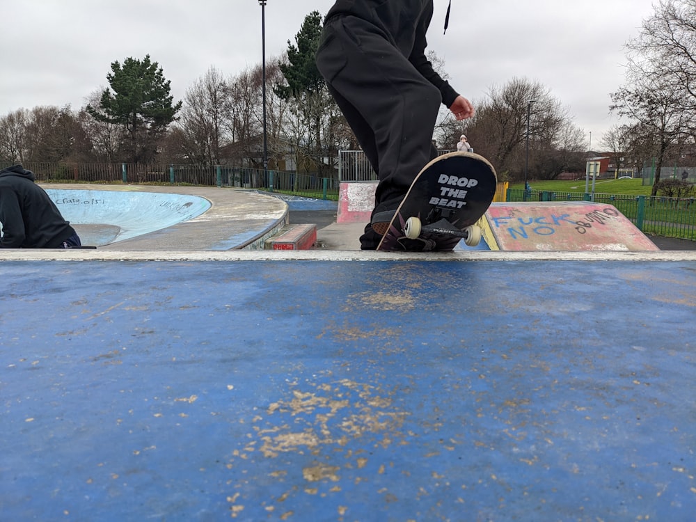a man riding a skateboard on top of a blue ramp